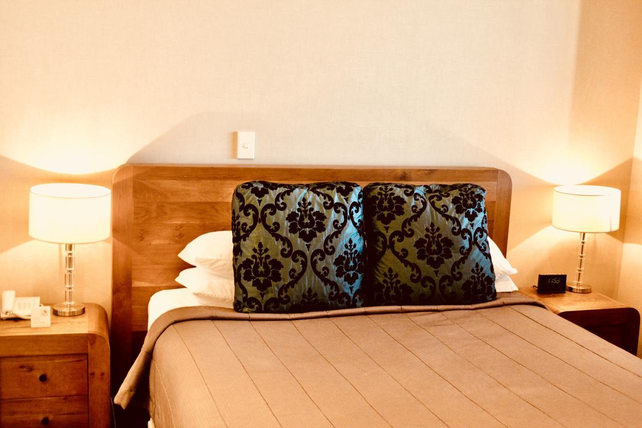 Отель The Nautilus Нейпир Экстерьер фото A bed with a decorative pillow