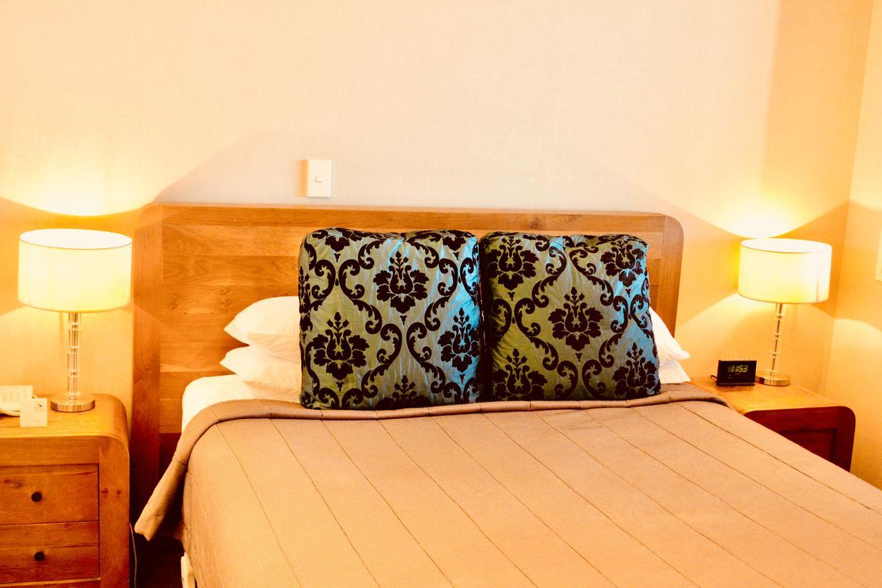 Отель The Nautilus Нейпир Экстерьер фото A bed with a decorative pillow